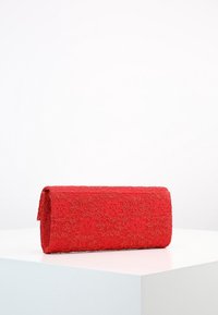 Czerwona kopertówka z teksturowanej tkaniny w kwiatowy wzór. Posiada złożony fason oraz gładkie, zaokrąglone krawędzie.