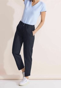 Ljusblå randig V-ringad T-shirt kombinerad med marinblå skräddarsydda byxor med slät front, sidfickor och ankellång längd.