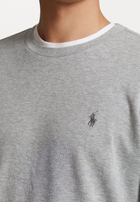 Grauer Sweatshirt aus Baumwollmischung, mit klassischem Rundhalsausschnitt und kleinem schwarzen Polo-Logo auf der linken Brust.