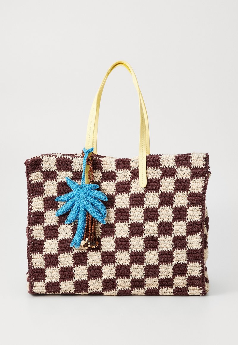 Sac cabas en crochet à carreaux marron et beige avec anses jaunes, orné d'un charme décoratif feuille bleue et perles marron.