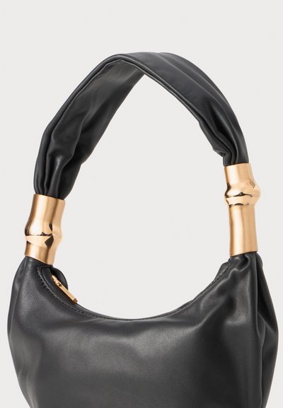 Schwarze Lederhandtasche mit einer weichen, geschwungenen Form. Verfügt über einen geknoteten Griff und goldfarbene Metallakzente an den Befestigungspunkten.
