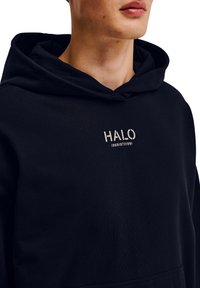 Czarna bluza z kapturem z kieszenią kangurką, z regulowanym kapturem i wytłoczonym na piersi logo "HALO" w jasnym kolorze. Miękka, teksturowana tkanina.