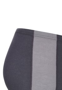 Nahaufnahme eines zweifarbigen Stoffpaneels in Dunkel- und Hellgrau mit sichtbaren Nähten auf einer gebogenen Oberfläche.