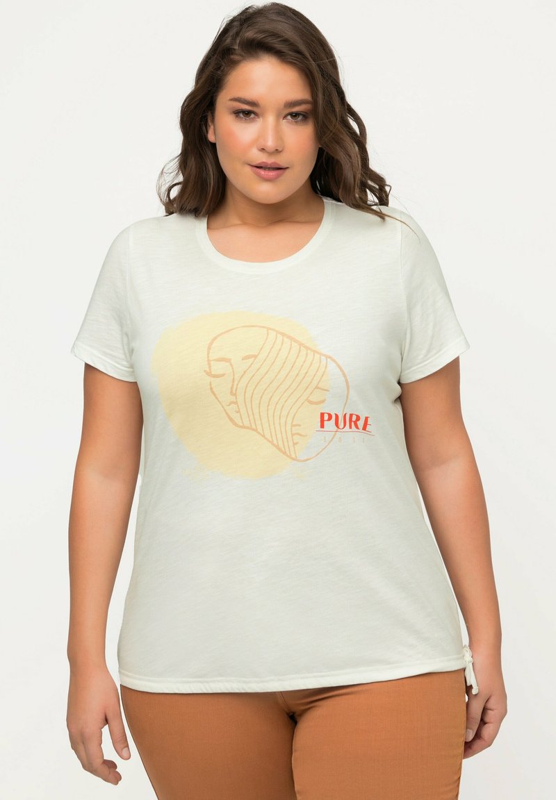 T-shirt verde chiaro con un disegno minimale a linee di due volti e una forma astratta gialla sullo sfondo. Testo "PURE" in rosso. Vestibilità morbida e casual.