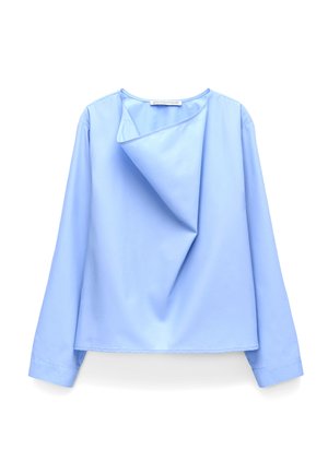 Lichtblauwe blouse met lange mouwen en asymmetrisch gevouwen kraagdetail, gemaakt van gladde stof, weergegeven op een witte achtergrond.