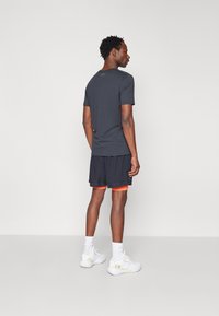Under Armour VANISH WOVEN - 2-in-1 shorts - black/fire/pitch gray