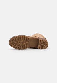 Stivaletto alla caviglia in suede color nocciola con albero testurizzato e suola in gomma dotata di un motivo antiscivolo per migliore aderenza. Struttura resistente con punta arrotondata.