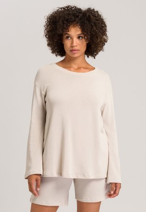Top de manga larga beige con escote redondo y hombros caídos, combinado con pantalones cortos a juego. Tejido suave y ligero con un corte relajado.