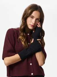 Black fingerless gloves made of soft knit material, featuring a ribbed texture and contrasting dark color against a burgundy sweater.