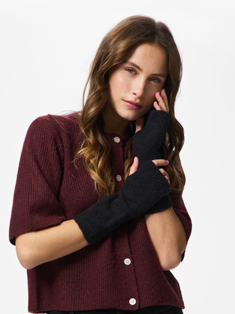 Black fingerless gloves made of soft knit material, featuring a ribbed texture and contrasting dark color against a burgundy sweater.