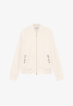 Cream-colored bomber jacket with front zipper and small floral embroidery near pockets, displayed against a white background.