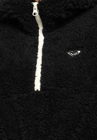 Zwarte fleece trui met een kwartrits en witte rits. Voorzien van een klein zilverkleurig geborduurd logo. Zachte, gestructureerde stof.