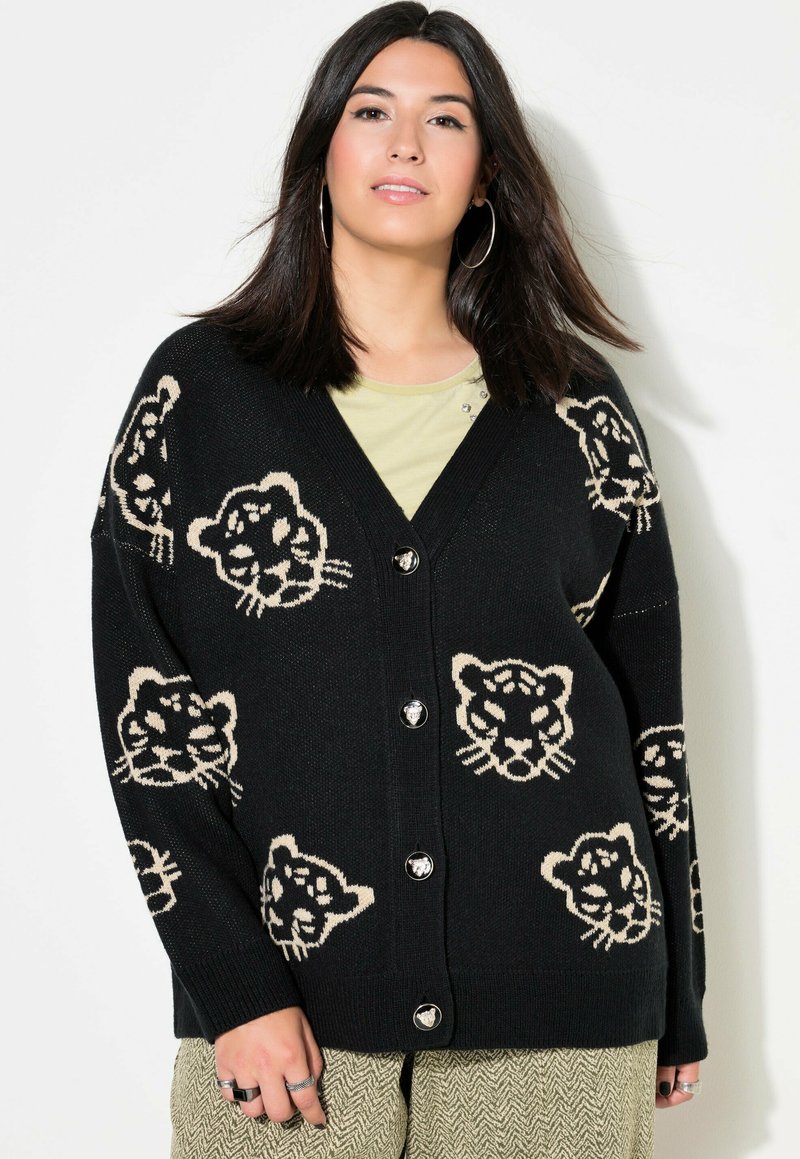 Mustapaita, jossa on V-pääntie ja beige leopardikuvio. Siinä on suuret napit ja pudotetut olkapäät rentoa istuvuutta varten.