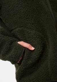 Tume roheline fleece-jakk, millel on tekstuuriga pehme pind, küljetasku ja tõmblukuga sulgemine. Tumedama varjundiga äärised.