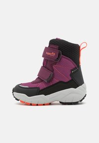 Kinderschuh aus lila und schwarzem Material für den Winter mit doppelten Klettverschlüssen, orangefarbener Schlaufe und robustem weißen und orangefarbenen Sohlen, seitlich dargestellt.