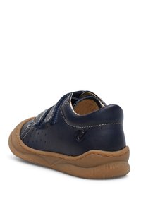 Námořnické modré kožené boty s perforovanými detaily, kontrastním prošíváním a hnědou gumovou podrážkou. Uzavření na suchý zip. Hladký povrch.