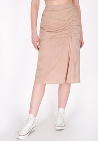 Beige midi rok met geplooide textuur, bloemenpatroon, zijsplit en zachte stof. Gecombineerd met witte hoge sneakers.