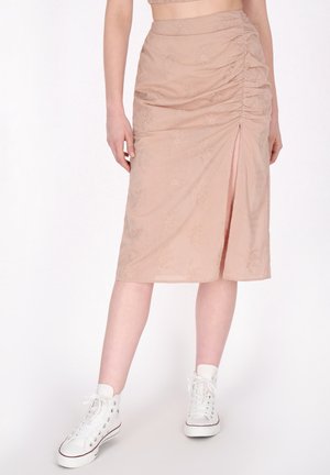 Beige midi-hame, jossa on poimutettu pinta, kukkakuosi, sivuhalkio ja pehmeä kangas. Yhdistetty valkoisiin korkeatoppaisiin tennareihin.