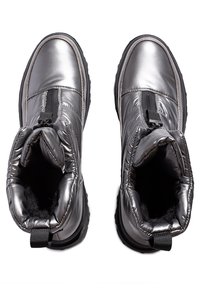 Botas tobilleras gris metálico con parte superior acolchada, frente elástico y suelas de goma negra. Incluye una lengüeta para facilitar el calzado.