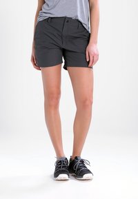 Grå shorts lavet af letvægtsstof, med flad front, sidelommer og en afslappet pasform, parret med sorte sportssko.
