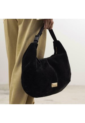 Sac à main en fausse fourrure noire avec une texture pelucheuse, doté d'une large bandoulière et de détails en matériel doré. Le sac a une forme douce et arrondie.