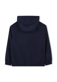 Giacca a vento blu navy con cappuccio, polsini elastici e fondo regolabile. Texture liscia, design leggero e cuciture minime.