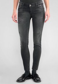 Zwarte skinny jeans met een vervaagde textuur, voorzakken met metalen accenten en een slim fit van taille tot enkel.