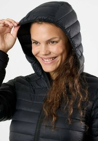 Black insulated jacket with a hood, featuring a quilted design, smooth texture, and zipper closure, worn over a black top.