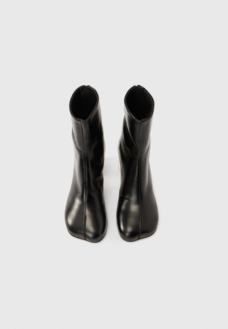 Sorte ankelstøvler i læder med et slankt, konisk design, lynlåse i siden og en glat tekstur, der har spidst tåparti og få pyntedetaljer.