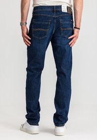 Niebieskie dżinsy o prostym kroju, z dwoma tylnymi kieszeniami, kontrastowymi przeszyciami oraz naszywką z logo na pasku talii.