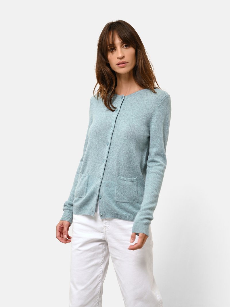 Světle modrý kardigan vyrobený z jemného materiálu, s uzávěrem na knoflíky, dvěma předními kapsami a žebrovanými manžetami.