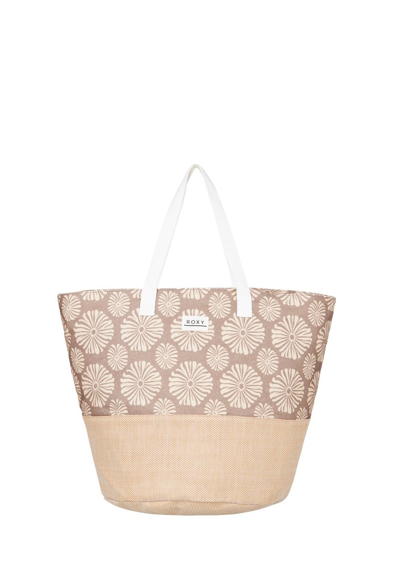 Canvas axelväska med blommig mönster i beige och vitt, vita handtag och en strukturerad botten i beige. Har en logotyp-patch på sidan.