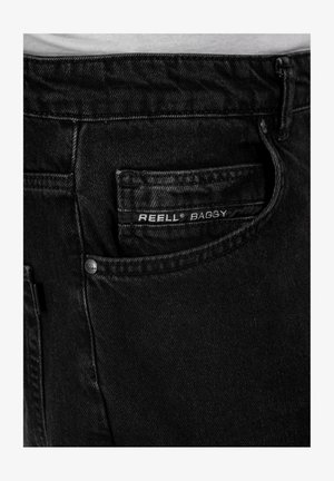 Black baggy jeans made of denim, featuring a back pocket with a visible label "REELL BAGGY" and a metal button accent.
