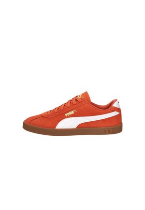Lage Puma sneaker in verbrande oranje suède met witte zijstreep, gum rubberen zool en gouden Puma-logo op de zijkant en tong.
