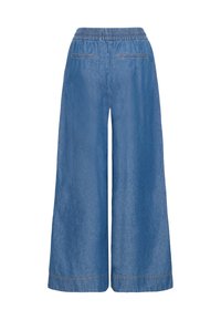 Denimbukser med vide ben i lyseblå med elastisk midje. Har to baklommer og synlige sømmer langs kanten.