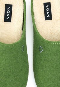 Green felt slippers with a soft cream lining, featuring a small embroidered logo on each side and a smooth, rounded design.