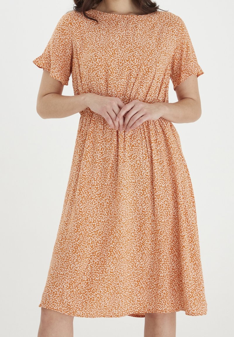 Krótkosleeve sukienka w kształcie litery A w pomarańczowym kolorze z białym abstrakcyjnym wzorem, z elastycznym pasem i miękkim, lekkim materiałem.