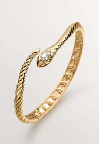 Pulsera de oro en forma de serpiente con un patrón texturizado, una piedra clara incrustada en un extremo y una superficie interior lisa.