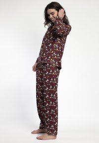 Conjunto de pijama burdeos con mangas largas y pantalones, que presenta un estampado de dibujos animados. Tela suave con un corte relajado y cuello estándar.