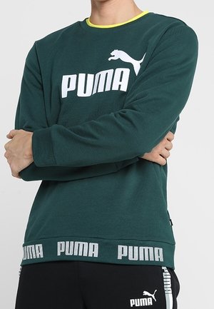 Zielona bluza z okrągłym dekoltem i żółtym obszyciem, z dużym białym logo "PUMA" z przodu oraz markowanym elastycznym dołem.