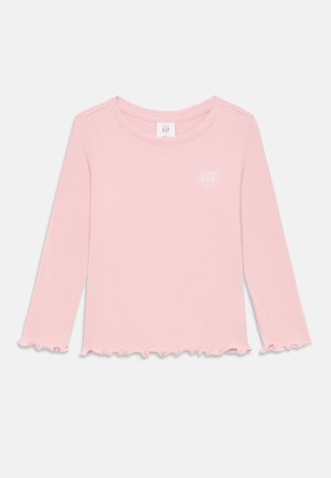 Top de manga larga, de canalé en rosa suave con dobladillo y puños con puntilla. Presenta un pequeño logo de corazón blanco en el lado izquierdo del pecho.