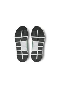 Black rubber shoe soles with textured tread patterns, featuring white accents and a mint green upper section extending to the heel.