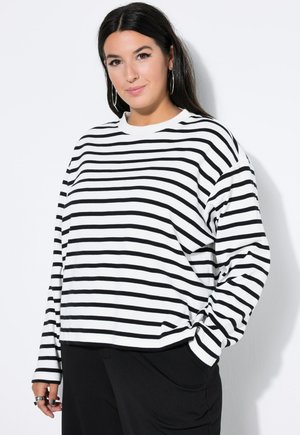 Camisa de manga larga a rayas blancas y negras con cuello redondo, corte relajado y tejido suave, que presenta un diseño simple sin acentos adicionales.