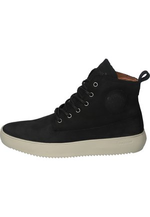 Zapatilla alta de ante negra con cordones de ojal, suela de goma y forro interior marrón. Presenta un acento de logo circular en el costado.