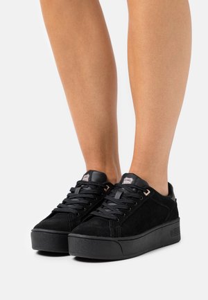 Sneaker in suede nero con una suola platform nera spessa, caratterizzate da lacci neri, un accentuazione in pelle sul tallone e un'etichetta con logo sulla linguetta.