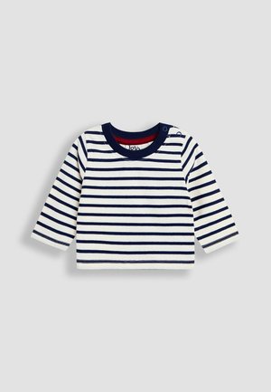 Pitkähihainen raidallinen paita valkoisena ja laivastonsinisenä, jossa on pyöreä pääntie punaisella vuorella ja nepparit olkapäällä helpottamaan pukemista.