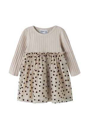 Robe bébé beige à manches longues en maille côtelée avec jupe transparente ornée de petits motifs en forme de cœurs noirs.