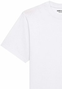 T-shirt blanc en coton à manches courtes avec encolure ronde et coutures visibles, montrant le haut devant et la manche gauche.