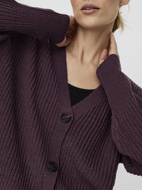 Violet knitted cardigan with a v-neck, long sleeves, and three large black buttons. Features a textured pattern and relaxed fit.