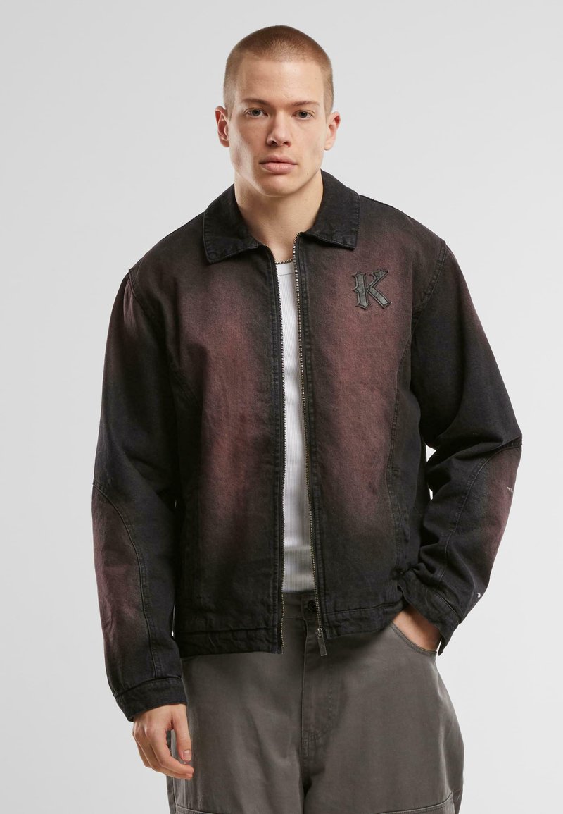 Svart og burgunder gradient denimjakke med glidelås foran, krage og teksturert brodert bokstav "K" på venstre bryst.